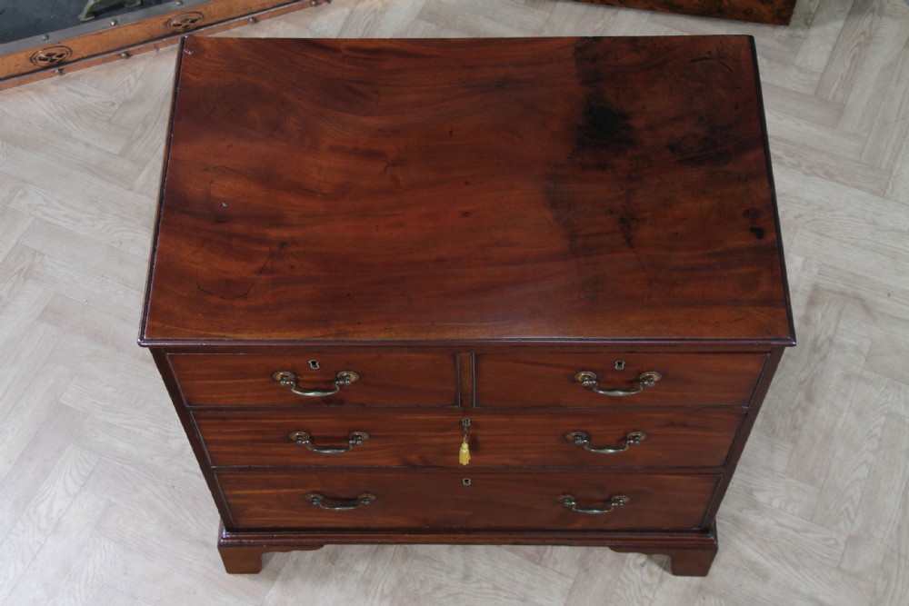 An eighteenth-century Georgian mahogany chest of drawers featuring four drawers with brass swan-neck handles and bracket feet. View VIII