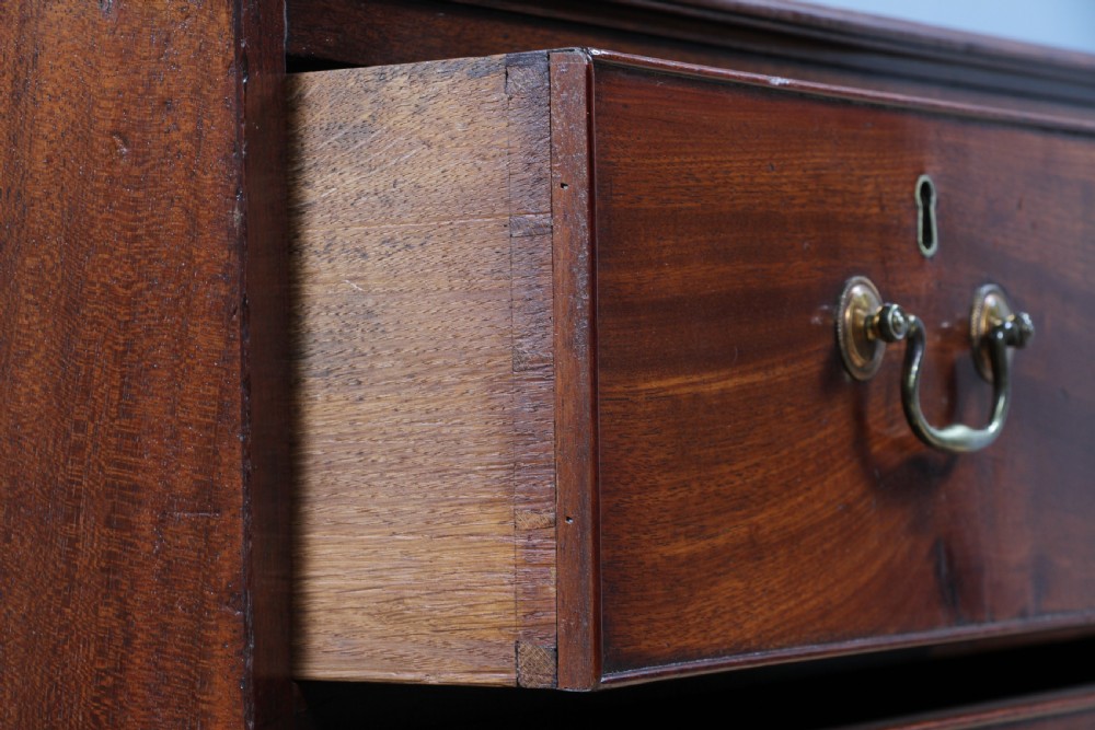 An eighteenth-century Georgian mahogany chest of drawers featuring four drawers with brass swan-neck handles and bracket feet. View XI
