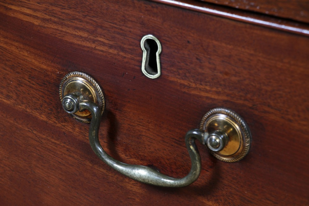 An eighteenth-century Georgian mahogany chest of drawers featuring four drawers with brass swan-neck handles and bracket feet. View XII