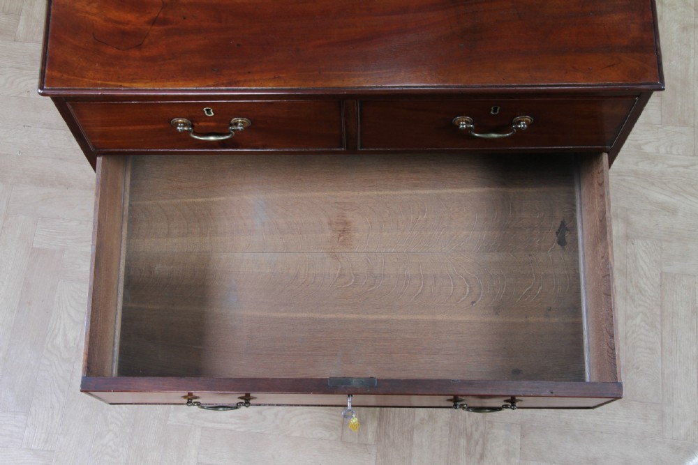 An eighteenth-century Georgian mahogany chest of drawers featuring four drawers with brass swan-neck handles and bracket feet. View XV