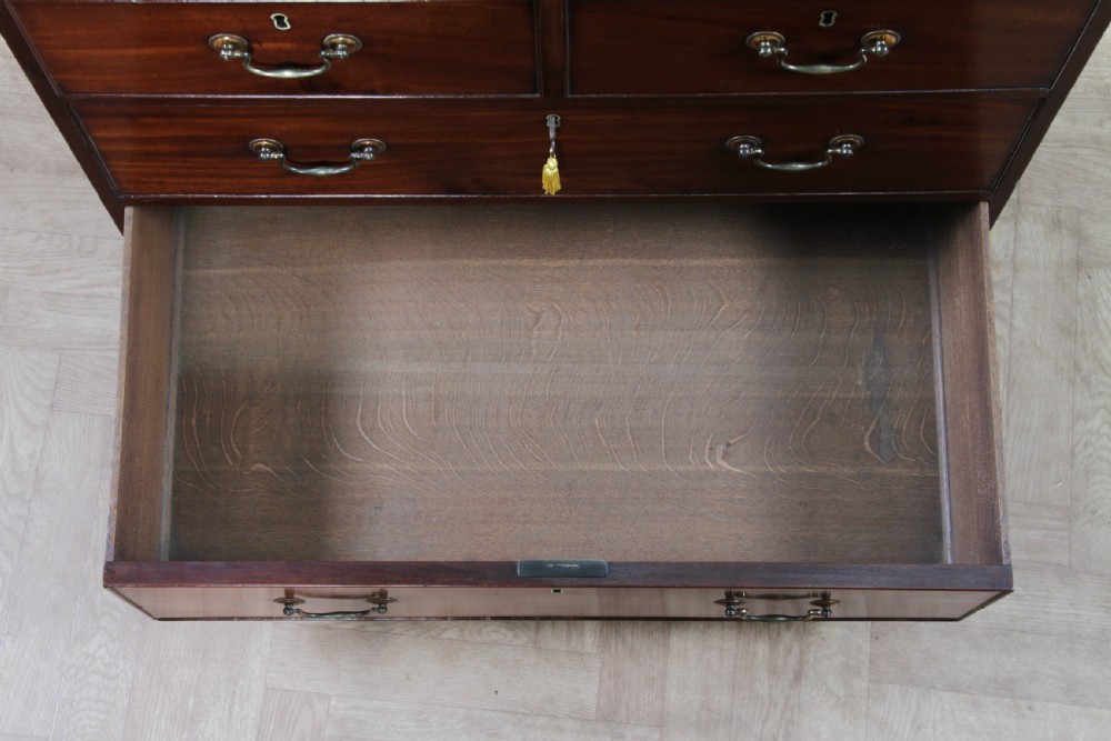 An eighteenth-century Georgian mahogany chest of drawers featuring four drawers with brass swan-neck handles and bracket feet. View XVI