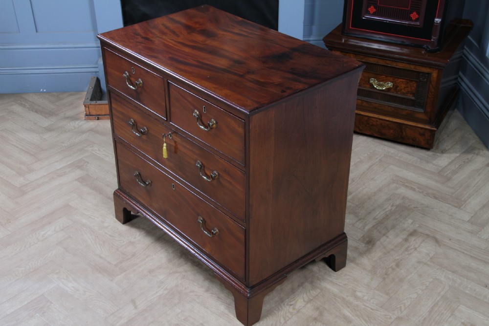 An eighteenth-century Georgian mahogany chest of drawers featuring four drawers with brass swan-neck handles and bracket feet. View XVIII