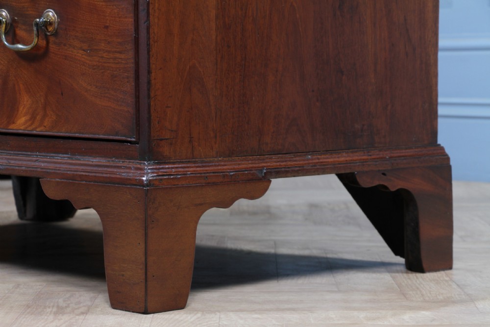 An eighteenth-century Georgian mahogany chest of drawers featuring four drawers with brass swan-neck handles and bracket feet. View XXI