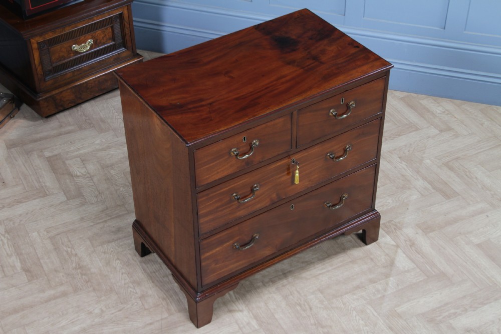 An eighteenth-century Georgian mahogany chest of drawers featuring four drawers with brass swan-neck handles and bracket feet. View XXII