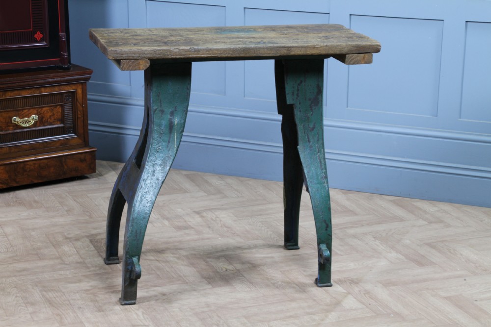 An industrial console table featuring distressed blue painted cast iron machinery legs supporting a rectangular reclaimed pine top. View II