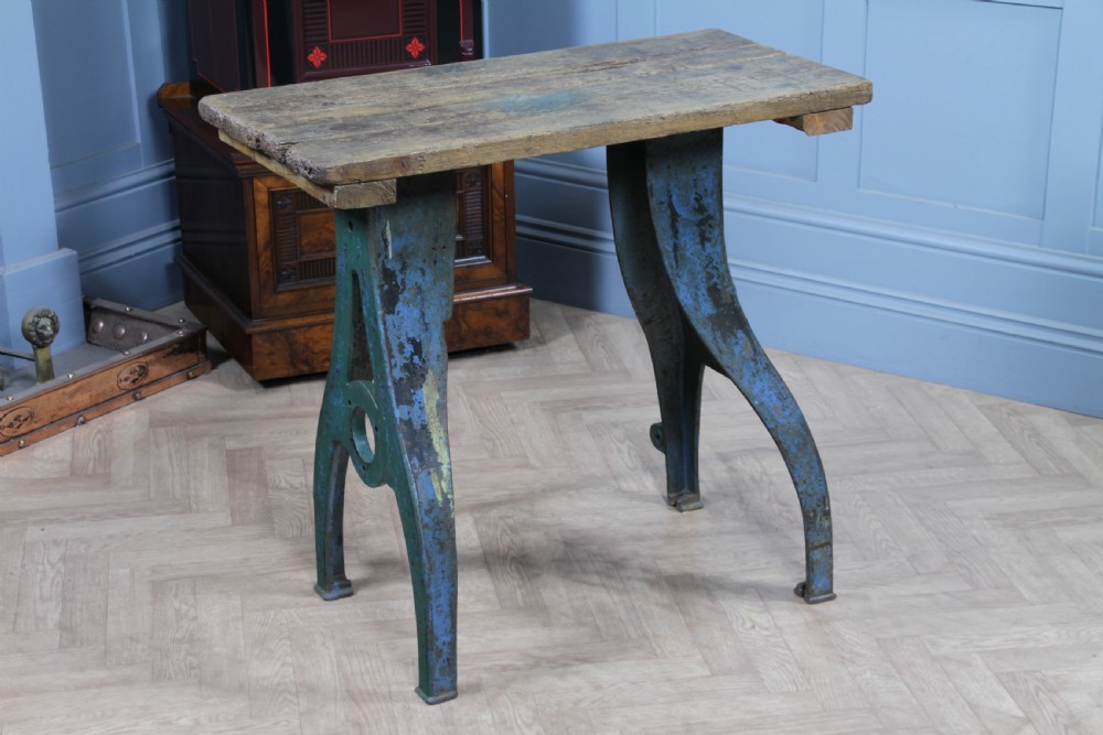 An industrial console table featuring distressed blue painted cast iron machinery legs supporting a rectangular reclaimed pine top. View IV