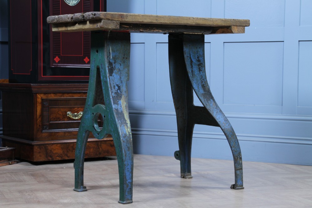 An industrial console table featuring distressed blue painted cast iron machinery legs supporting a rectangular reclaimed pine top. View V