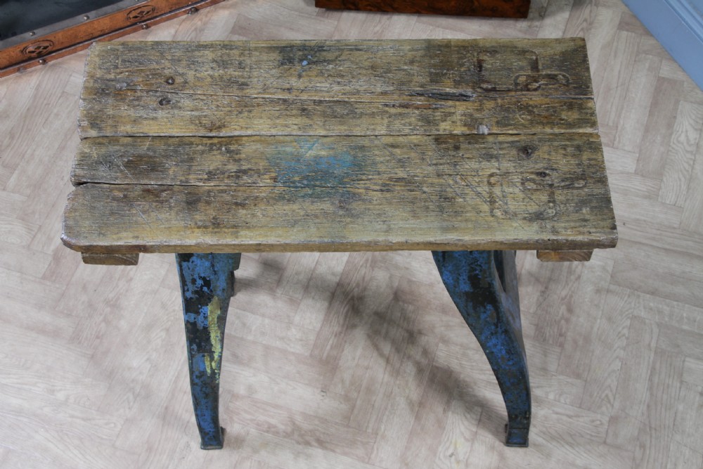 An industrial console table featuring distressed blue painted cast iron machinery legs supporting a rectangular reclaimed pine top. View VI