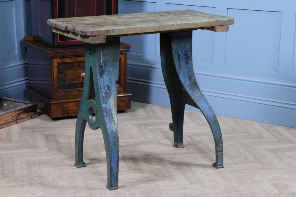 An industrial console table featuring distressed blue painted cast iron machinery legs supporting a rectangular reclaimed pine top. View VII