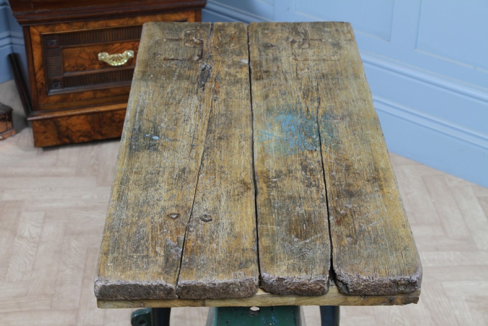 An industrial console table featuring distressed blue painted cast iron machinery legs supporting a rectangular reclaimed pine top. View XVIII