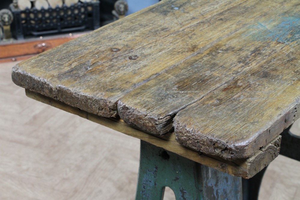 An industrial console table featuring distressed blue painted cast iron machinery legs supporting a rectangular reclaimed pine top. View XIX