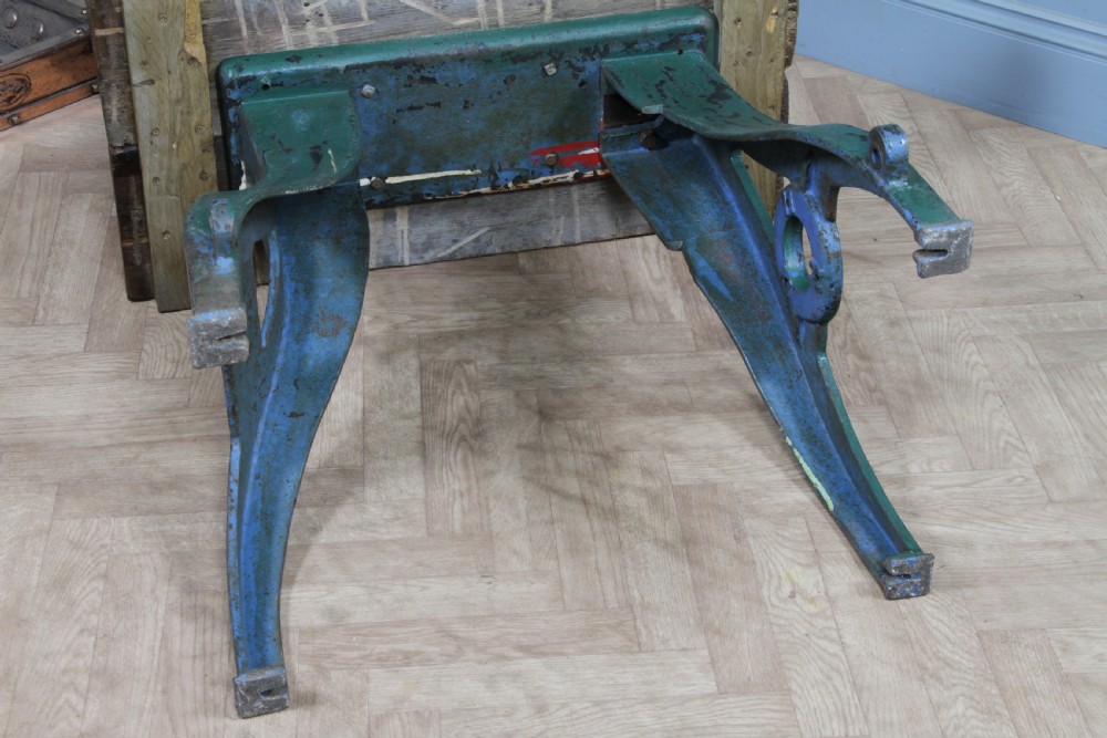 An industrial console table featuring distressed blue painted cast iron machinery legs supporting a rectangular reclaimed pine top. View XX