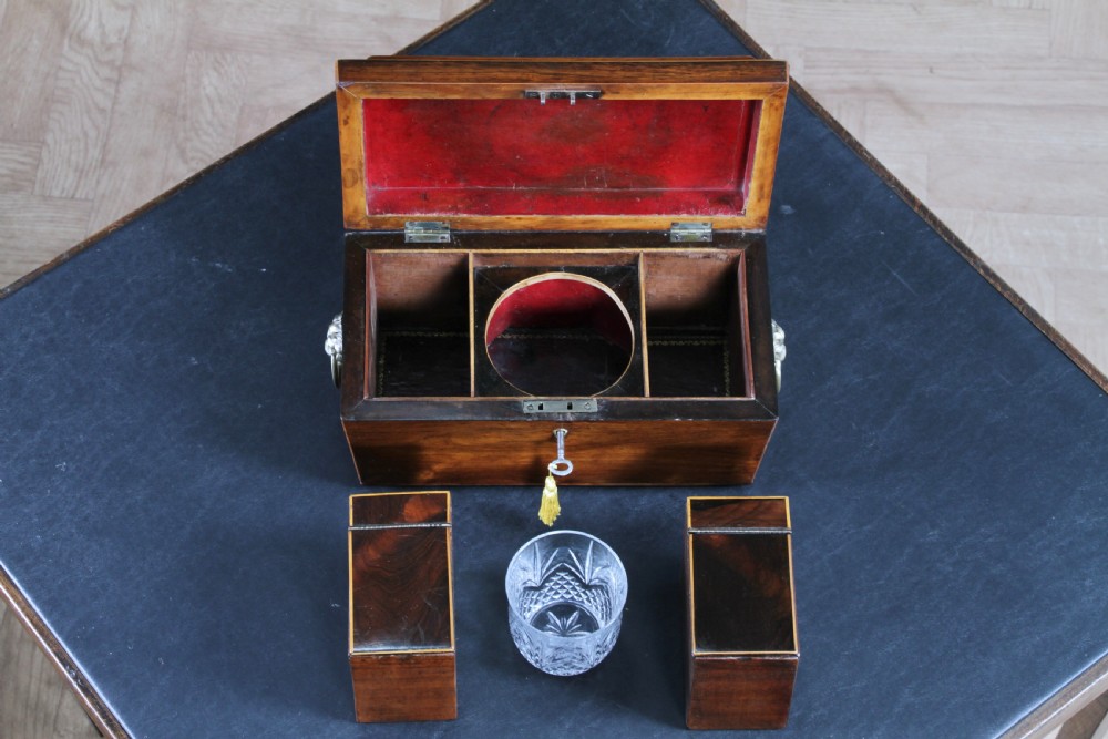 A Georgian rosewood sarcophagus-form tea caddy featuring stringing inlay, brass lion-mask side handles, and a keyhole with a tasselled key. View IV