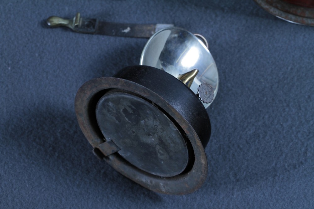 An antique black painted iron GWR railway hand lantern featuring a circular glass lens, top handle, brass accents, and a red painted band near the base. View XXII