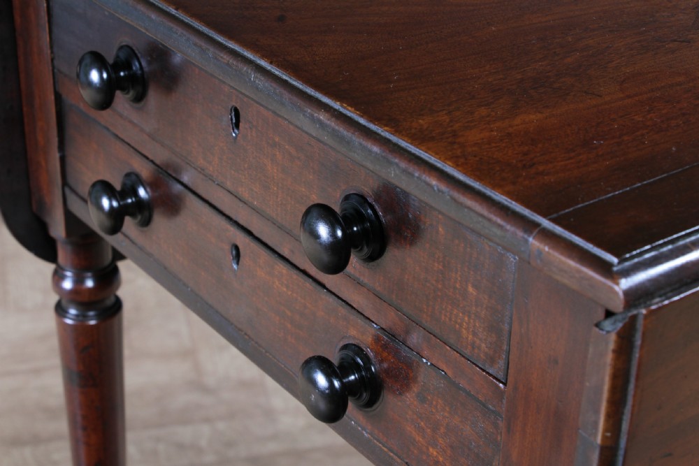 A George III mahogany Pembroke table featuring drop leaves, turned legs on brass castors, and an open drawer fitted with a green baize writing slope and compartments. View X