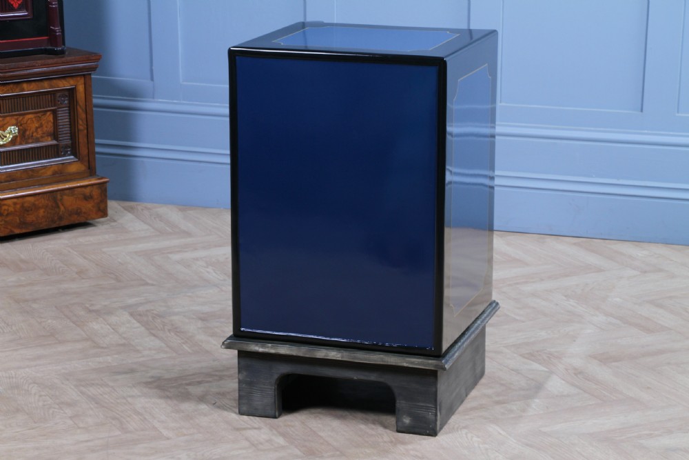 A restored Victorian navy blue and black cast iron safe featuring polished brass hardware and a makers plaque, raised on a dark wooden plinth. View XXI