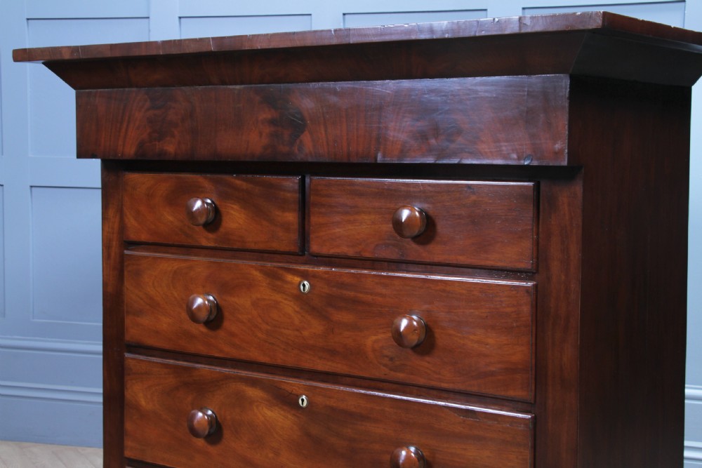 A Georgian Scottish mahogany chest on chest featuring eight drawers with turned wooden knobs, fluted side columns, and an overhanging pediment cornice. View VII