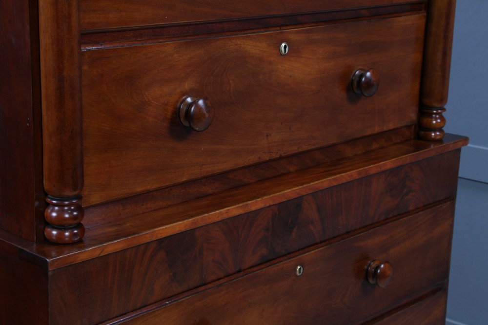 A Georgian Scottish mahogany chest on chest featuring eight drawers with turned wooden knobs, fluted side columns, and an overhanging pediment cornice. View IX