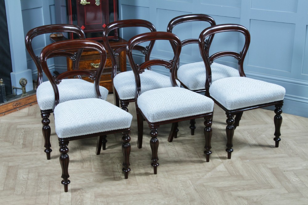 A set of six Victorian mahogany balloon back dining chairs featuring turned front legs and light grey chevron-patterned upholstered seats. View II