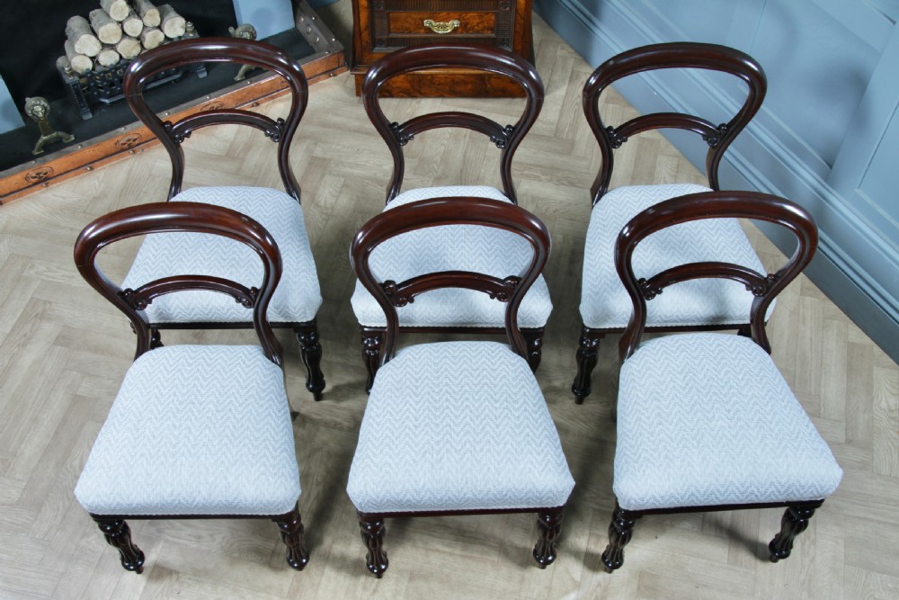 A set of six Victorian mahogany balloon back dining chairs featuring turned front legs and light grey chevron-patterned upholstered seats. View IV