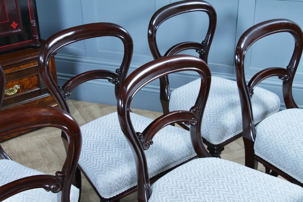 A set of six Victorian mahogany balloon back dining chairs featuring turned front legs and light grey chevron-patterned upholstered seats. View VI
