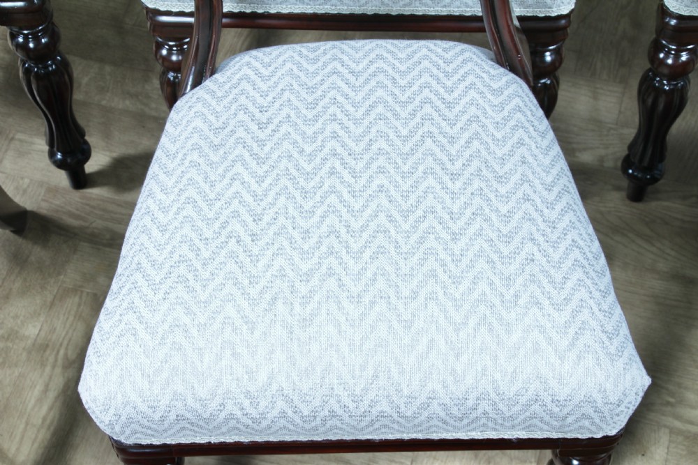 A set of six Victorian mahogany balloon back dining chairs featuring turned front legs and light grey chevron-patterned upholstered seats. View X
