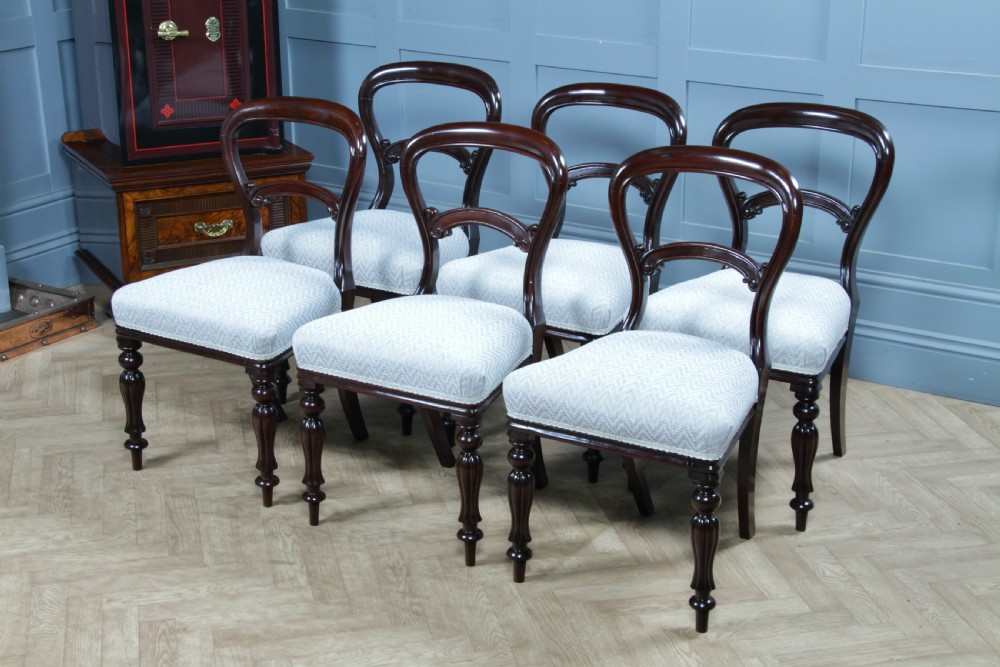 A set of six Victorian mahogany balloon back dining chairs featuring turned front legs and light grey chevron-patterned upholstered seats. View XV