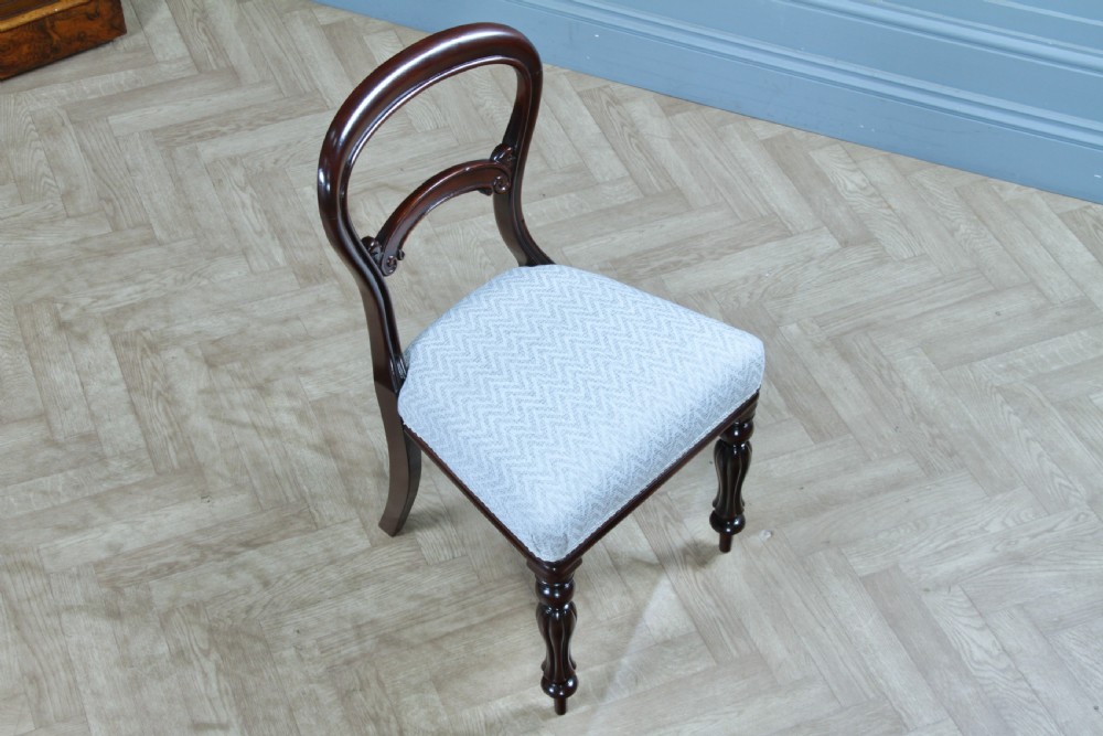 A set of six Victorian mahogany balloon back dining chairs featuring turned front legs and light grey chevron-patterned upholstered seats. View XX