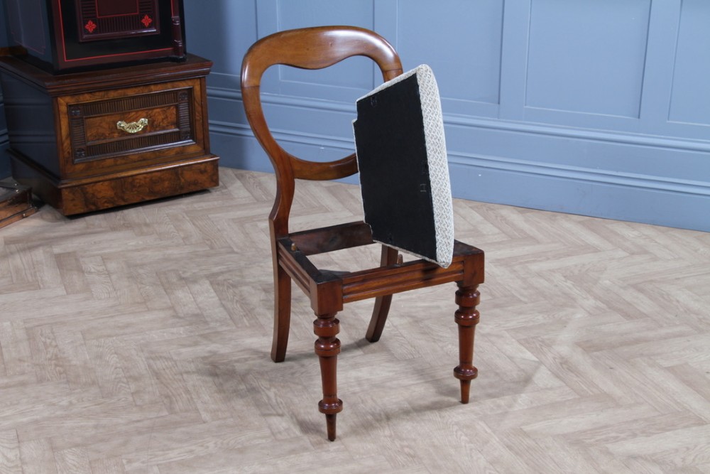 A set of eight Victorian mahogany dining chairs featuring open rounded balloon backs, turned front legs, and neutral patterned upholstered seats. View XIV
