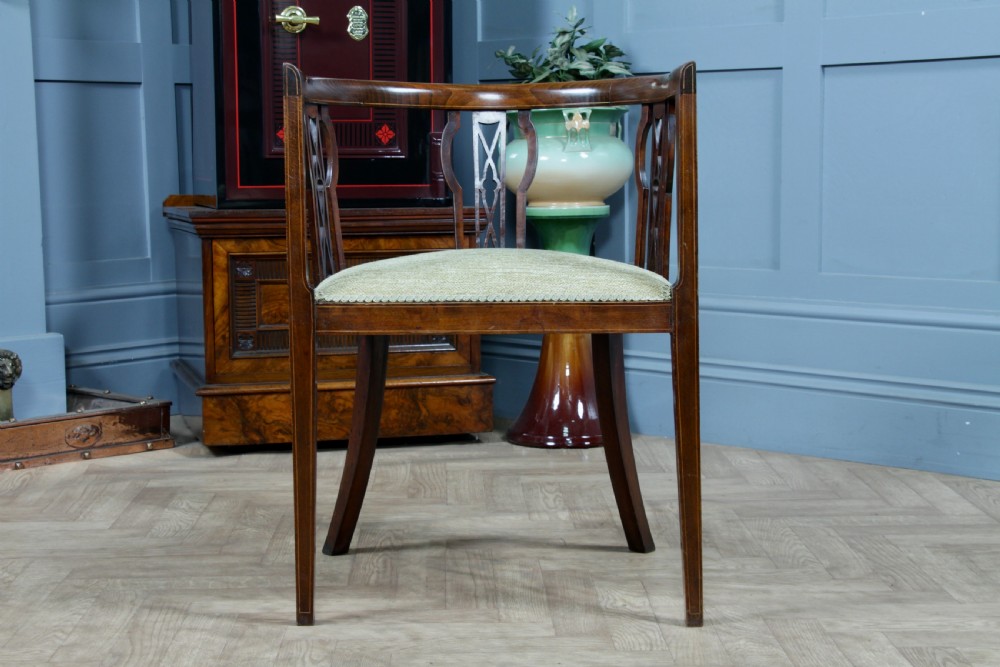 An Edwardian inlaid mahogany tub armchair featuring a continuous curved backrest, pierced splats, and a sage green upholstered seat. View II