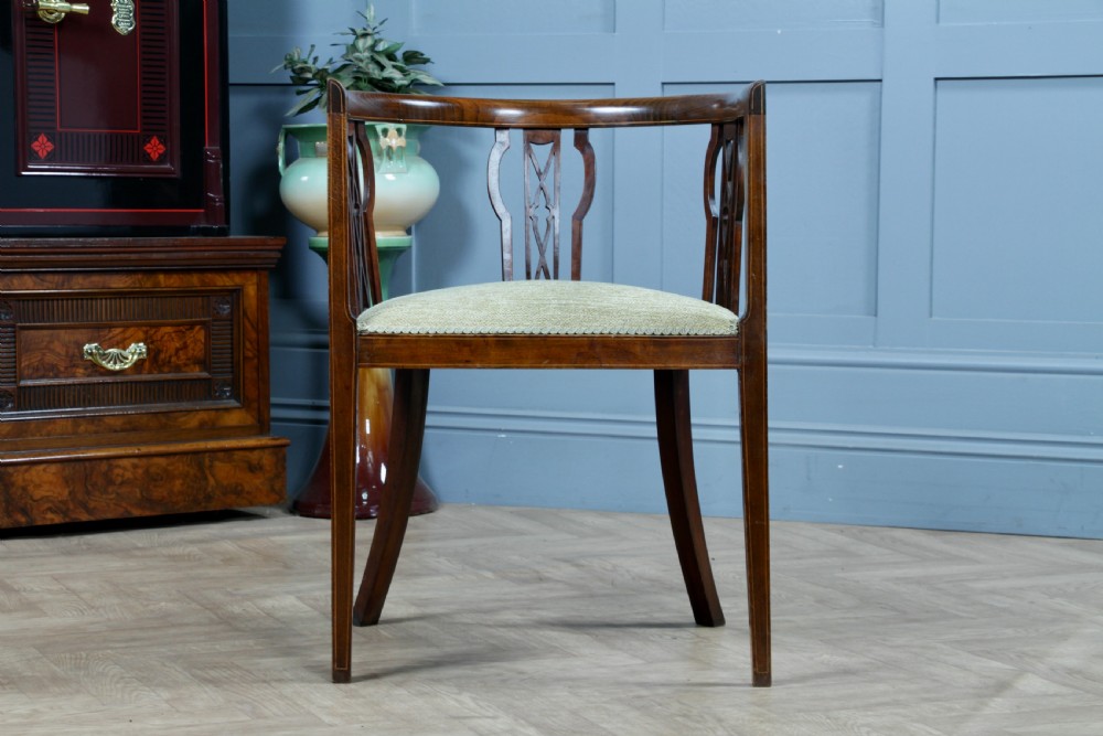 An Edwardian inlaid mahogany tub armchair featuring a continuous curved backrest, pierced splats, and a sage green upholstered seat. View XII