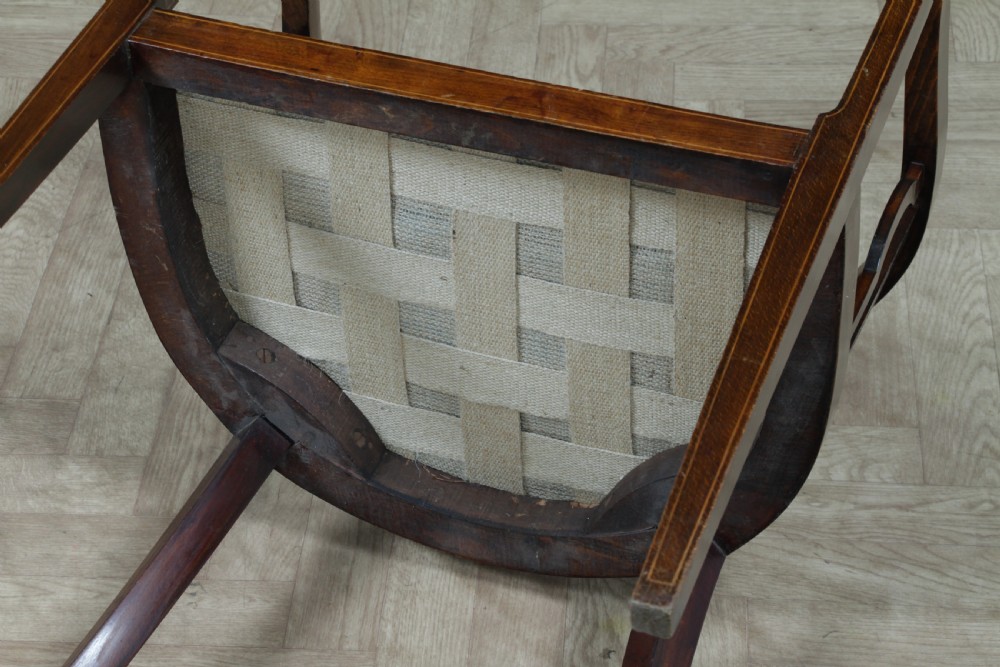 An Edwardian inlaid mahogany tub armchair featuring a continuous curved backrest, pierced splats, and a sage green upholstered seat. View XVI