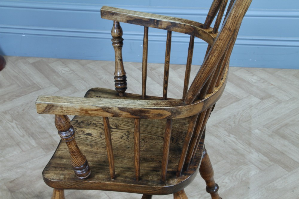 A traditional high-back Windsor armchair crafted from ash and elm wood, featuring a pierced central splat, spindled backrest, turned legs, and a cow horn stretcher. View V
