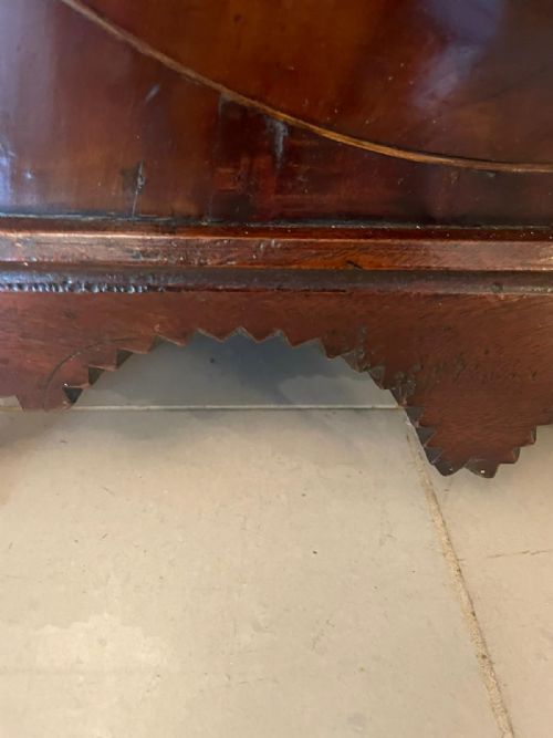 fig 3. A George III mahogany longcase clock featuring a swan neck pediment with a brass finial, a painted arch dial, and an inlaid trunk door.