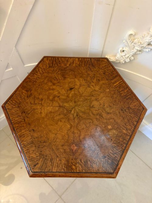 fig 4. An antique hexagonal pollard oak side table featuring a lift-top lid, ring-turned column supports, and a carved tripartite base with castors.