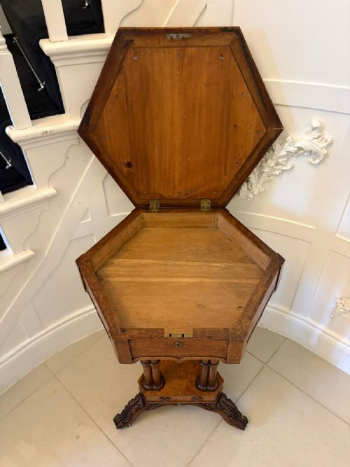 fig 5. An antique hexagonal pollard oak side table featuring a lift-top lid, ring-turned column supports, and a carved tripartite base with castors.