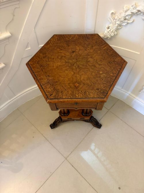 fig 6. An antique hexagonal pollard oak side table featuring a lift-top lid, ring-turned column supports, and a carved tripartite base with castors.
