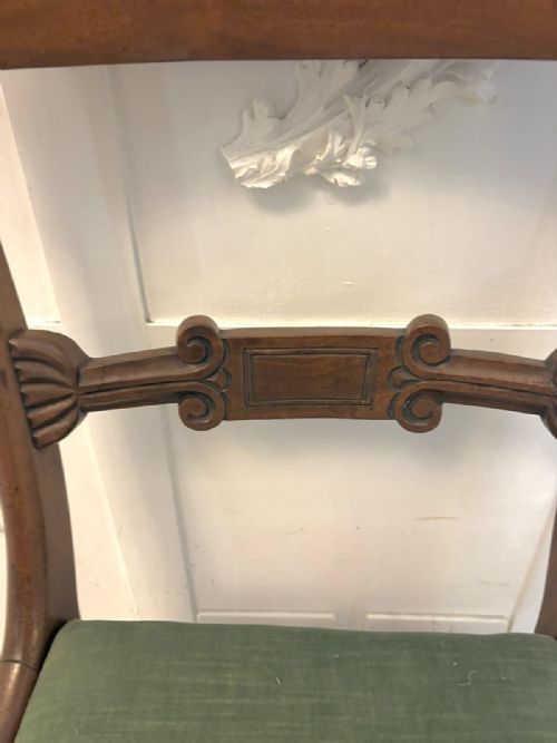 fig 3. A set of eight antique Regency mahogany dining chairs featuring green velvet upholstery, turned front legs, and two scroll arm carvers.