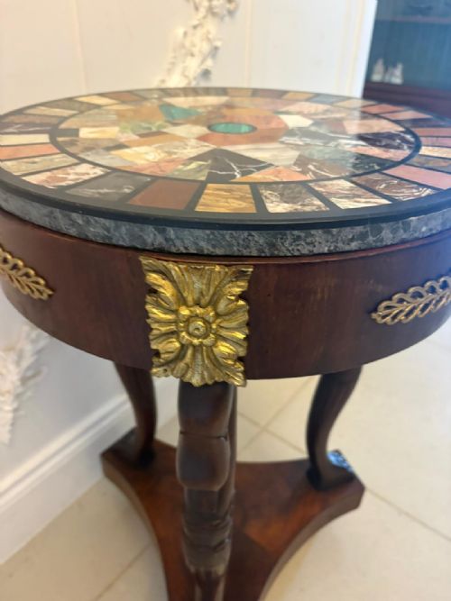 fig 3. A circular antique side table with a specimen marble top, mahogany apron with brass mounts, and carved swan supports on a triform base.