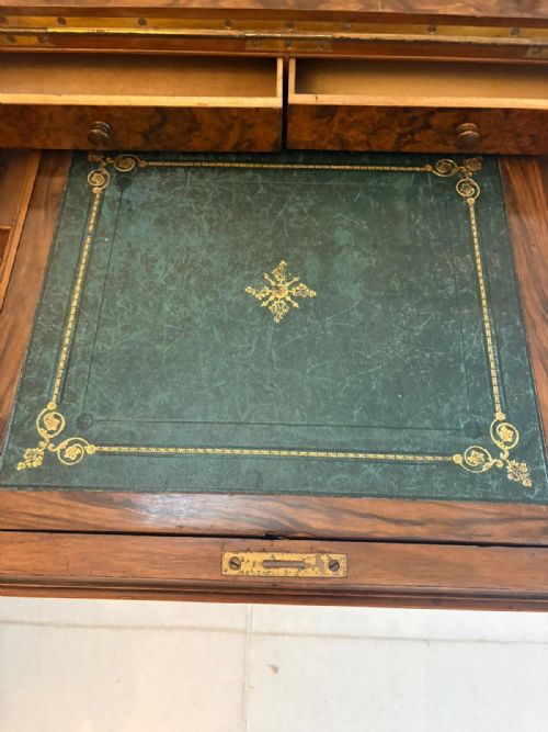 fig 2. An antique Victorian burr walnut piano top Davenport desk featuring intricate floral marquetry, side drawers, and carved supports.