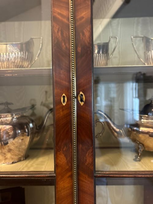 fig 2. A Georgian mahogany secretaire bookcase featuring an upper two-door astragal glazed cabinet set over a lower chest of five drawers with brass swan-neck handles.