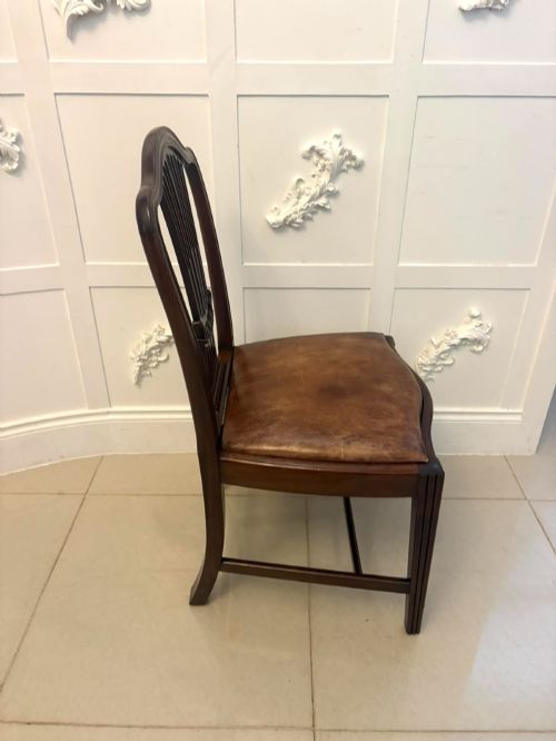 fig 4. A set of Victorian mahogany Hepplewhite style dining chairs featuring shield-shaped backs with carved splats and tan leather upholstered seats.