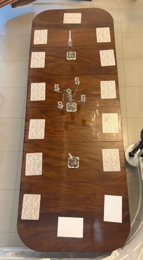 fig 2. A large, polished Regency mahogany extending dining table with rounded corners and reeded legs fitted with brass castors.