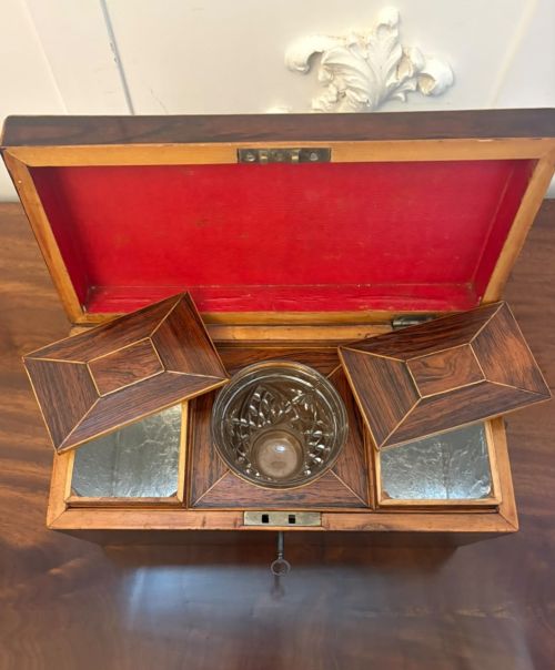 fig 2. A Regency period dark rosewood tea caddy featuring brass stringing inlay, a faceted lid, and a central keyhole with key inserted.