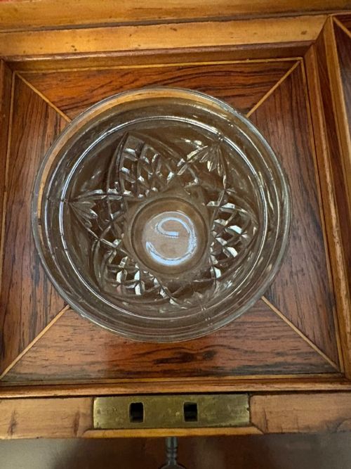 fig 4. A Regency period dark rosewood tea caddy featuring brass stringing inlay, a faceted lid, and a central keyhole with key inserted.