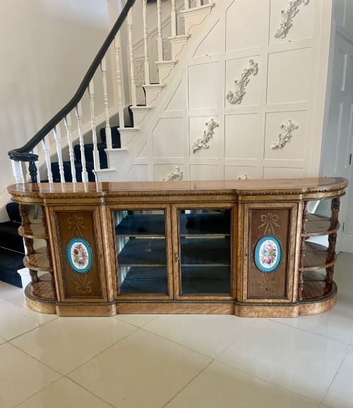 fig 5. A large Victorian satinwood credenza featuring central glazed doors, oval porcelain plaques, and open curved side shelves.
