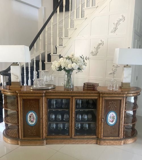 fig 6. A large Victorian satinwood credenza featuring central glazed doors, oval porcelain plaques, and open curved side shelves.