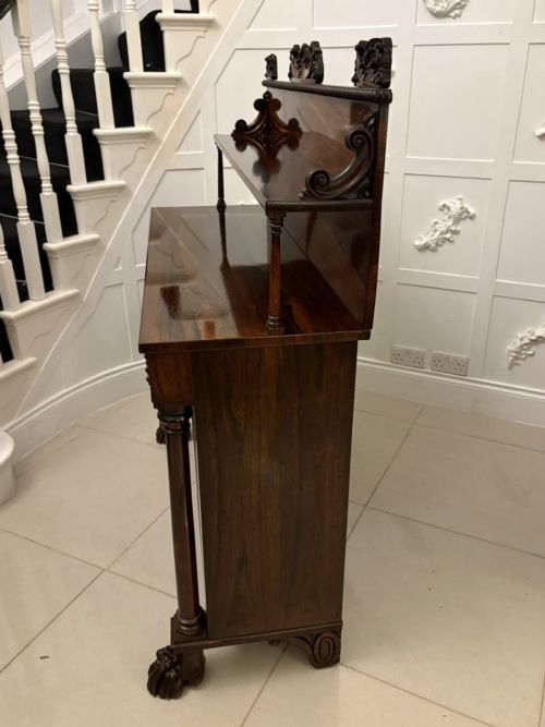fig 2. A dark mahogany Regency chiffonier sideboard featuring a two-door lower cupboard, turned support columns, carved claw feet, and a raised upper display shelf with a carved scroll cresting.