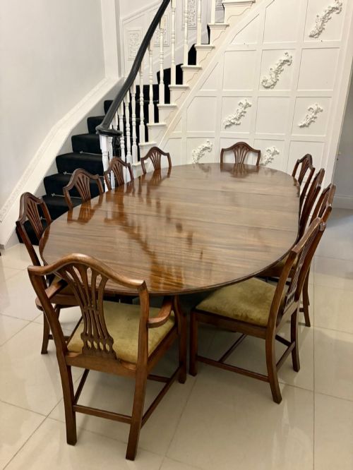 fig 1. An antique oval extending mahogany dining table on splayed pedestal legs with brass castors.