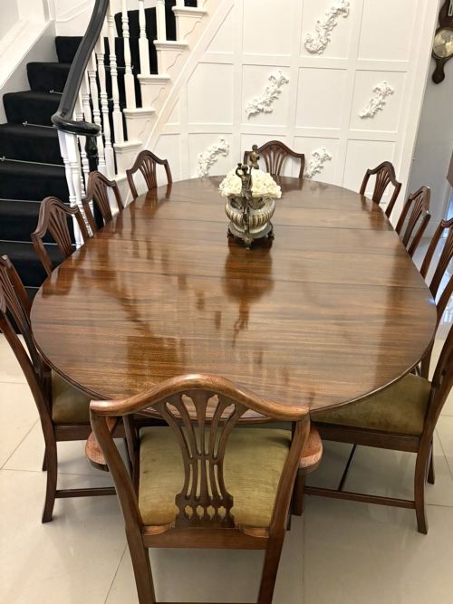 fig 2. An antique oval extending mahogany dining table on splayed pedestal legs with brass castors.